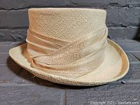 Side angle of Lilliput straw hat showing textured weave and satin ribbon, excellent condition.