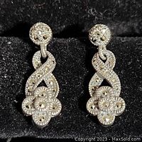 Front view of the pair of vintage sterling silver drop earrings showing detailed flower and infinity designs with marcasite-like stones.
