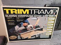 Box showing product image and features such as clean cuts, efficiency, portability, and versatility for mitre saw table.