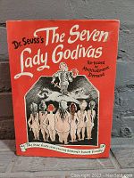 Front cover of The Seven Lady Godivas book by Dr. Seuss showing stylized title and artwork of seven nude women and a man on horseback.