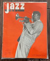 Cover of Jazz Hot magazine, November 1957, featuring Miles Davis playing trumpet on bright orange background.
