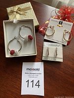 Pair of 925 silver hoop earrings with red and white crystal beads, two other pairs of earrings, one on card labeled Oxford Station, the other Continental Austrian Crystal, and a lot number card.