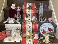 Photo showing various Christmas decorations including crocheted angels, CDs, towels, glass and butterfly ornaments, cardinal decorations on a table with a burgundy background