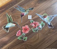 Set of three hummingbird magnets and three flower magnets placed on wooden surface, showing size and detail