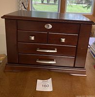 Front exterior view of the jewellery box showing four drawers and wooden finish.
