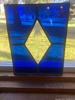 Front view of stained glass panel showing blue glass sections and clear diamond center with star etching.