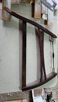 Full view of vintage hand saw showing wooden frame with reddish finish and attached metal blade.