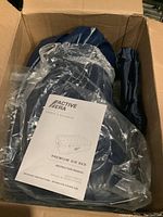 Active Era air bed parts packed inside a brown box including instruction manual on top.