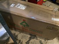 Closed cardboard box labeled National Tree Company containing the artificial Christmas tree.