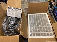 Air King fan and hardware organizer caddy shown in open boxes; fan wrapped in plastic with instruction sheet, organizer with multiple compartments visible
