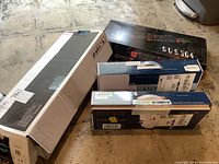 Photo showing all boxes in the lot including Luxe Bidet kits, SUS 304 stainless steel faucet box, and Delta faucet box on concrete floor.