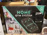 Box front showing 'Gonex Home Gym System' branding, featuring images of exercises using the system.