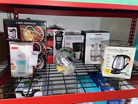 Shelving rack with all boxed kitchen appliances showing brand and product types