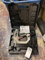 Arrow electric nailer ET200BN in black molded plastic carrying case with manual on top.