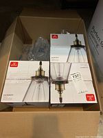 Three boxed Globe Jackson pendant lights in a large cardboard box with packaging materials.