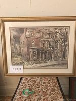 Full view of the framed print showing the architectural building scene in soft muted colors, with the frame and matting visible.