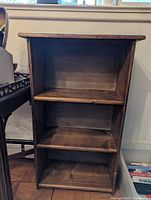 Front view of the 3-tier wooden shelving unit showing all three shelves and overall structure.