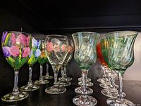 Photo showing the collection of wine glasses with floral handpainted and various colored designs.