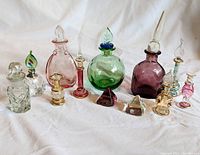 Lot of 12 assorted mouth blown Egyptian perfume bottles in various colors and unique glass stoppers