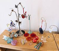 Full view of lot showing impression of all crystal and glass hanging decor on wooden tabletop against white wall.