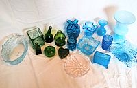 Overview of the depression glass collection showing assorted green and blue glassware with varied textures and shapes.