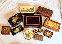 Photo showing all eleven jewelry boxes arranged on a white cloth, showcasing their variety in shapes and decorative styles.