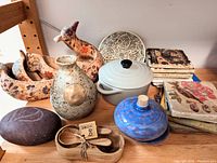 Overview photo showing all items together on a shelf including casserole dish, vase, blue jar, condiment holder with spoon, nesting bird bowls, and coasters.