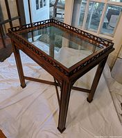 Full view of the vintage wooden table showing glass top and wooden legs