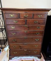 Frontal view showing 10-drawer dresser with brass handles and visible wood grain.