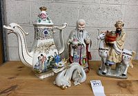 All four porcelain pieces displayed together against concrete block background