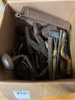 Box filled with multiple old metal and wooden hand tools, various shapes and sizes packed together.