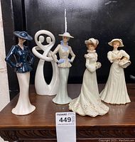 Full lot showing two Lefton woman figurines, two Lenox woman figurines in wedding-style dresses, and a modern white Circle of Love abstract sculpture