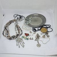 Grouping of jewelry: multi-strand bead necklace, rhinestone brooch, crystal bead necklaces, sterling silver chains and pendants, gold-tone locket on cord, small stud earrings, and Reed & Barton plated round tray