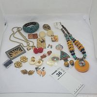 Photo of the entire mixed jewelry lot showing a variety of necklaces, earrings, brooches, pins, bracelets, and cufflinks.
