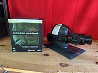 Photo of the tactical helmet with attached night vision goggles displayed on a black mannequin head next to the Modern Warfare 2 box.
