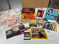 Full lot showing collection of cassette tapes, 45 RPM records, and bags/memorabilia