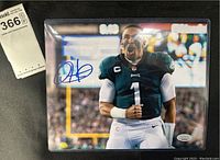 Front view of signed Jalen Hurts 8x10 photo in plastic protective sleeve, showing full image and autograph