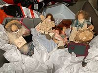 Full view of four vintage Lizzie High handmade cloth dolls arranged in box with tissue paper