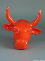 Front view of the red bull head wall hook with prominent horns showing the glossy finish and dimensional facial features.