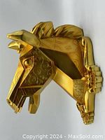 Front angled view of the gold geometric horse head wall decor showing swirl engraving and three-dimensional facets.