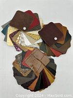 Top view of leather sample swatches showing a variety of colors and textures including solid colors, reptile patterns, embossed designs.