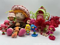 Photo shows full assortment of 13 Strawberry Shortcake items including assorted dolls, figurines, and a plastic closet.