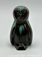 Front view of the polished ceramic owl figurine showing green and black glaze finish.