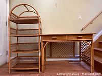 Complete view of the vintage wicker and rattan bookcase and desk showing their style and scale near a stairway.