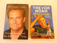 Two bestselling celebrity memoirs displayed side by side: Matthew Perry's hardcover memoir and Trevor Noah's softcover memoir.