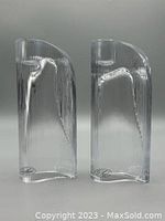 Front view of two clear ribbed crystal candle holders showing vertical ribbing and a curved top shape