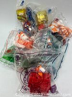 Eight Happy Meal toys in clear plastic sealed bags, showing multiple characters and packaging logos including Peanuts & NASA.