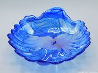 Top angle view of the blue glass clam shell shaped dish showing swirled cobalt blue coloring and shiny iridescent interior.