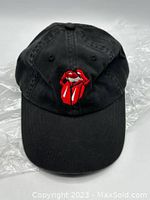 Front view of black baseball cap with red Rolling Stones logo embroidered on front panel.