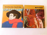 Two vintage hardcover art books side-by-side with full colorful dust jackets, one featuring Toulouse Lautrec and the other Max Ernst.